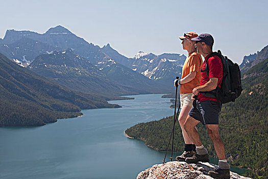 男性,女性,远足者,站立,石头,悬崖,向外看,湖,山峦,蓝天,沃特顿,艾伯塔省,加拿大