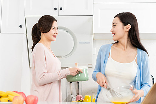 年轻女子在厨房边做饭边和朋友聊天