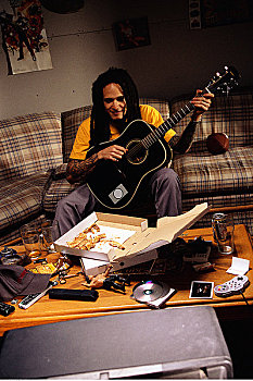 男人,坐,沙发,弹吉他,比萨饼盒,桌上