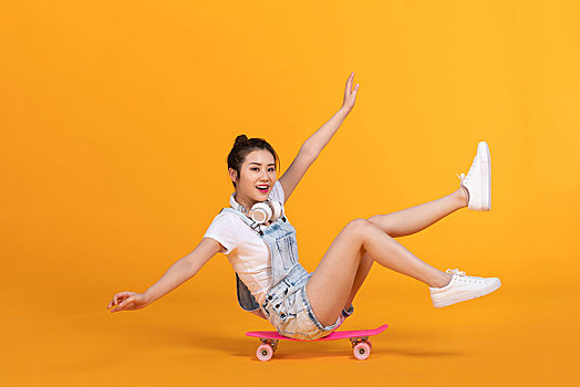 棚拍玩滑板的年輕女子