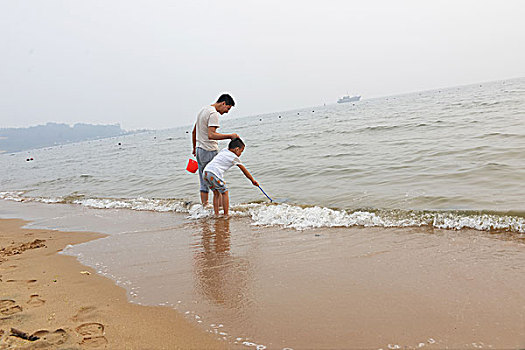 夏日大海边游玩的父子