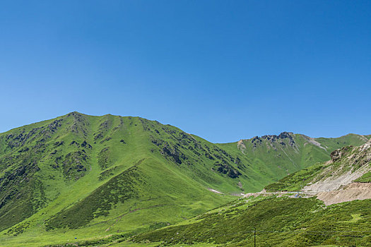 中国新疆夏季蓝天白云下g217独库公路沿途高山草原