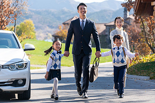 年轻夫妻送孩子去上学