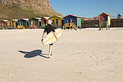 男人,冲浪板,走,沙滩,海滩小屋,后视图