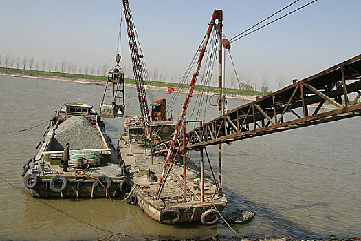江苏,运河上运送石料的船只在装卸