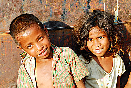 portrait,timorese,boy,and,girl,with,iron,background,rust
