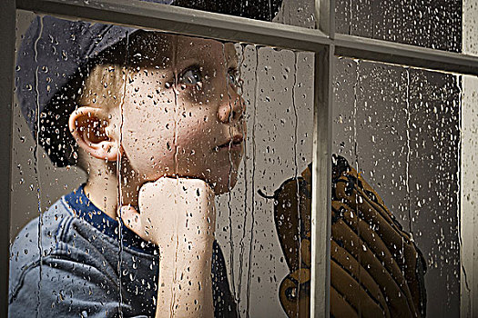 男孩,棒球手套,向窗外看,雨天