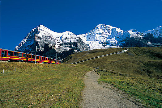 开往瑞士少女峰的火车行驶在阿尔卑斯山脉脚下