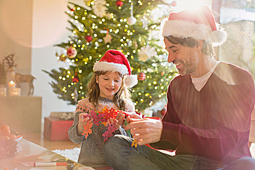 父亲,女儿,穿,圣诞帽,拿着,纸,雪花,靠近,圣诞树