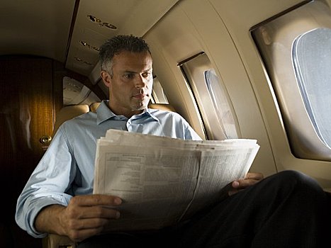 仰视,商务人士,读,报纸,飞机
