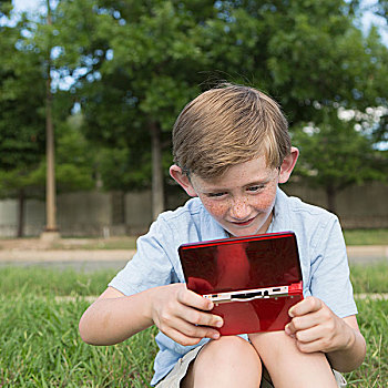 男孩,坐,草,玩,手持,电子游戏