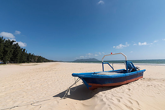 海南清水湾沙滩上的一只蓝色小船