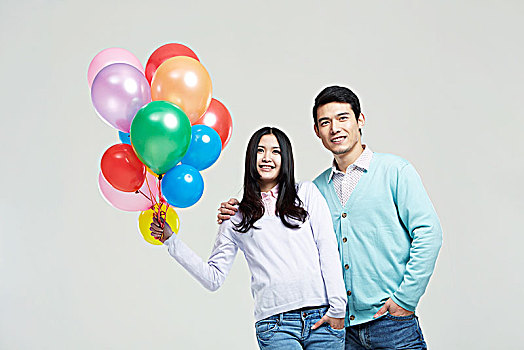 拿彩色气球的亚洲青年情侣