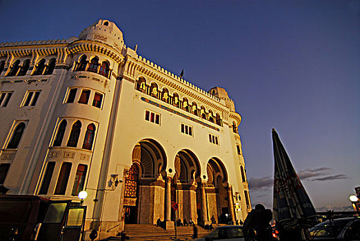 algeria,alger,low,angle,view,of,people,by,post,office,building,against,sky,at,dusk