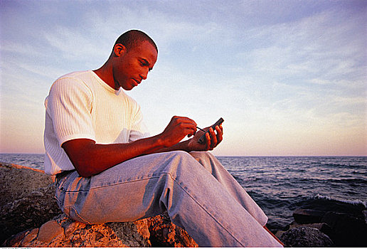 男人,坐,岩石上,靠近,水,电子记事簿
