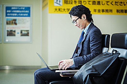 商务人士,戴着,套装,眼镜,坐,火车站,工作,笔记本电脑