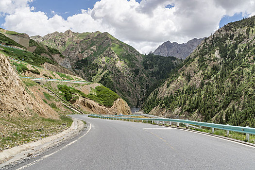 中国新疆夏季蓝天白云下高山森林g217独库公路弯道