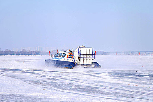 雪地上飞驰的气垫船激起白色的雪花
