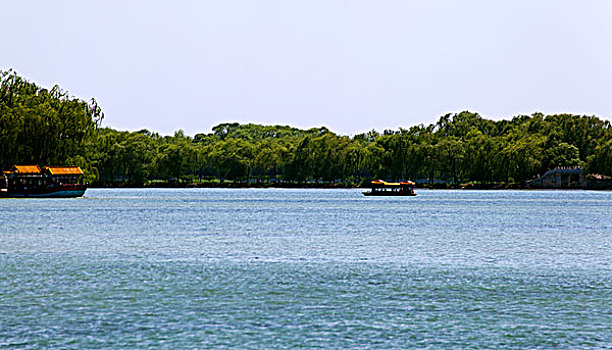 颐和园昆明湖上的游船和远处的石桥