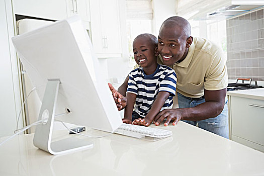 高兴,微笑,父亲,儿子,用电脑,厨房