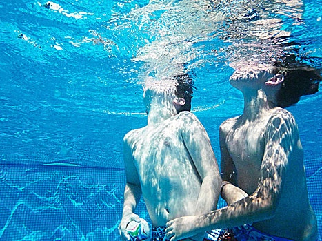 水下视角,两个男孩,玩,球类运动,游泳池