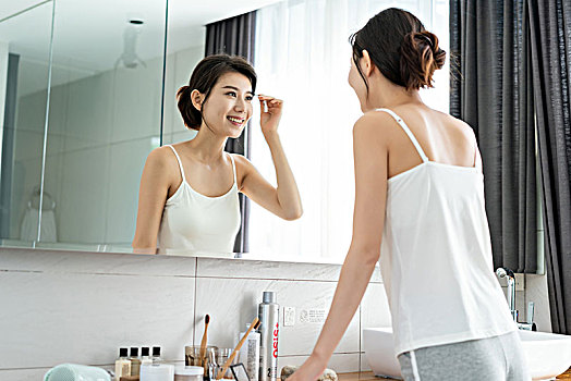 年轻女子照镜子整理妆容