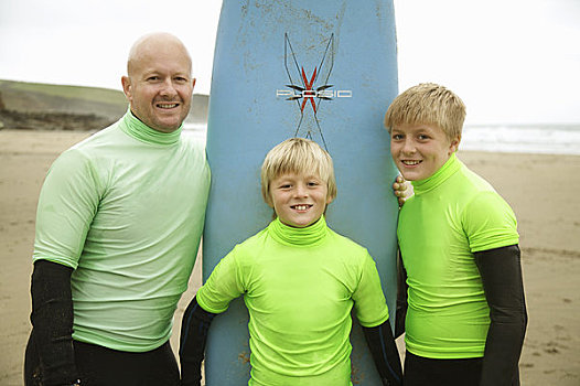 男人,两个男孩,穿,冲浪,紧身潜水衣,站立,竖立,冲浪板,海滩,微笑