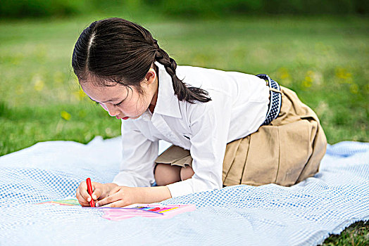坐在草地上学习的小女孩
