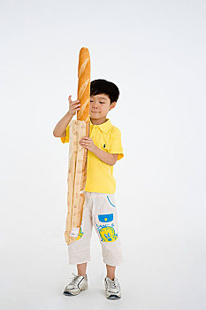 拿着面包对着镜头玩耍的小男孩