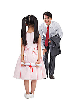 棚拍商务装年轻父亲,穿裙子的小女孩拿着奖状