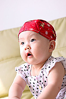 一名带着头巾8个月的女婴在室内玩