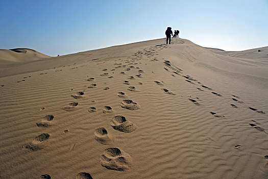 库布奇沙漠的徒步者和足迹