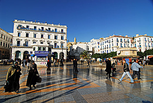algeria,algiers,reflection,of,building,on,pool,with,people,walking,tiled,floor,in,background