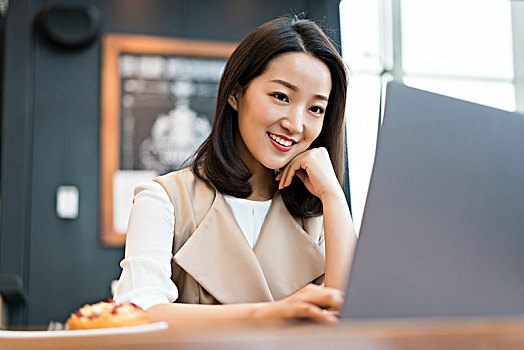 年轻女子在餐厅使用电脑