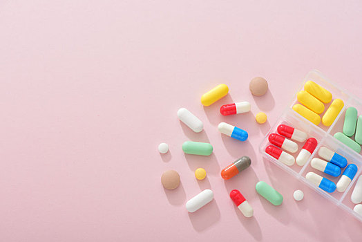 粉色背景上的药片和药盒