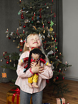 女孩,搂抱,娃娃,正面,圣诞树