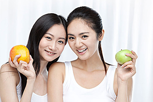 两个拿着苹果的亚洲青年女性