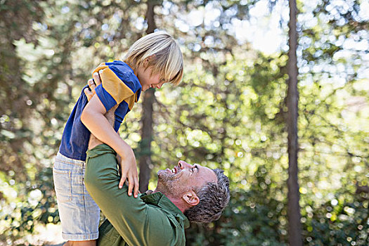 玩耍,父亲,举起,向上,儿子,树林,侧面视角
