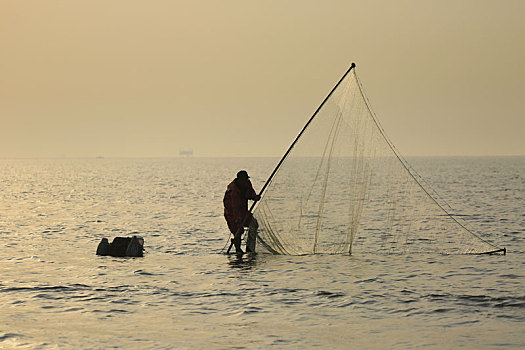 60岁的老渔民踩着高跷捕小虾,成了海边的一道独特景观