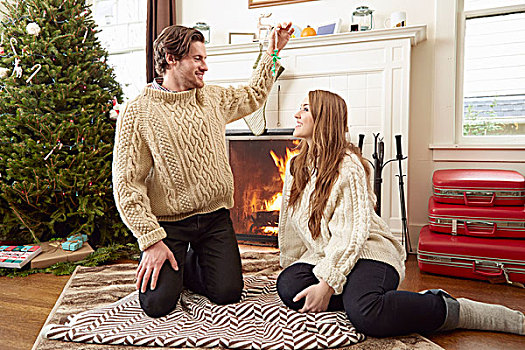年轻,情侣,坐,客厅,地毯,拿着,向上,圣诞装饰