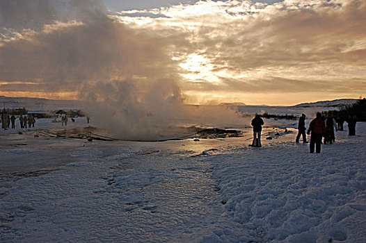 iceland,geysir,tourist,people,looking,at,steam,coming,out,from,the,geyser,in,snow,environment