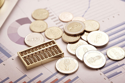 金融概念,放在财务数据报表上的算盘和硬币