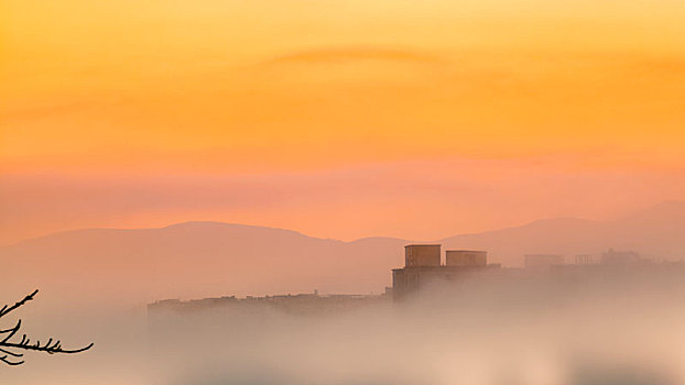 城郊的早晨,金色阳光与云雾在城市上空