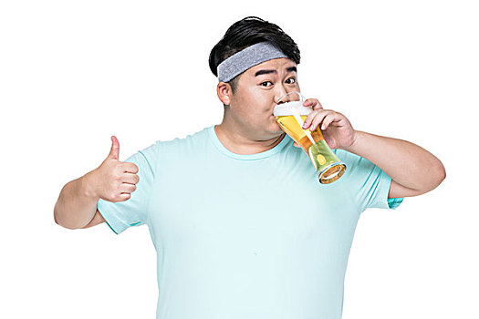 肥胖的年轻男子在喝啤酒