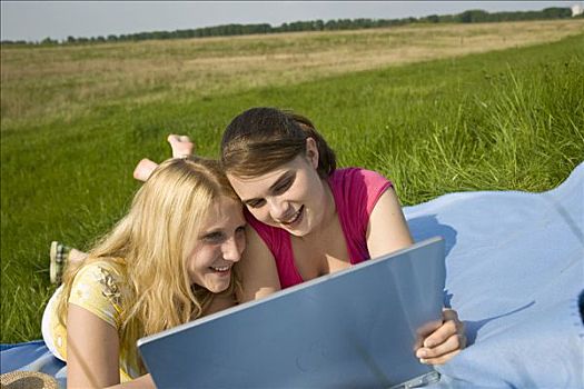 两个,微笑,女孩,笔记本电脑,躺着,毯子,草地