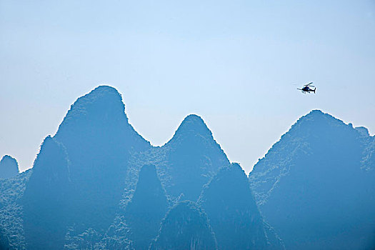 广西桂林兴坪镇漓江边群峰上的直升飞机