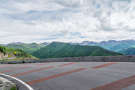 中国新疆夏季蓝天白云下高山森林g217独库公路弯道