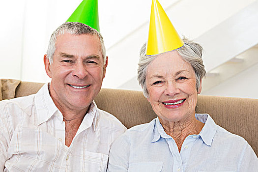 老年,夫妻,坐,沙发,穿,派对帽