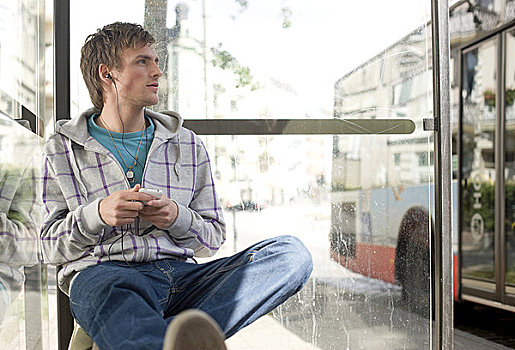 男青年,坐,公交车站,mp3播放器,仰视