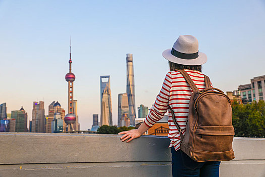 站在苏州河桥上欣赏上海城市风光的女性游客,上海旅游概念